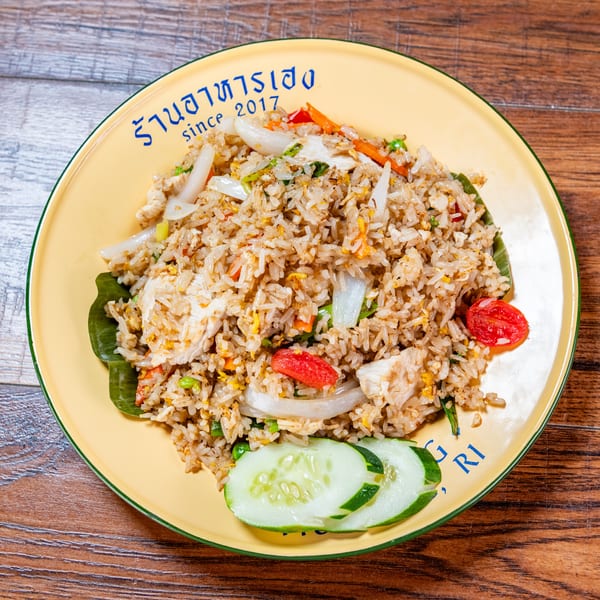 Chicken fried rice with vegetables and cucumber slices on a yellow plate with 'since 2017' text.