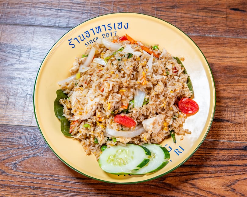 Chicken fried rice with vegetables and cucumber slices on a yellow plate with 'since 2017' text.